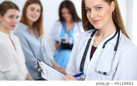 Young beautiful female doctor smiling while consulting her patient. Physician at work. Medicine and 44110601