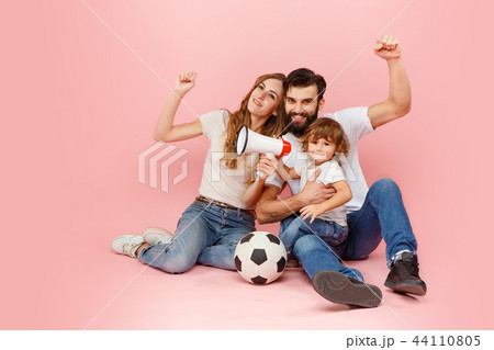 happy father and son playing together with soccer ball on pink 44110805