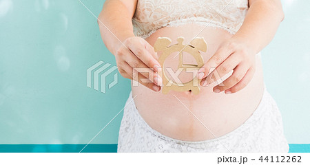 Pregnancy woman holding wooden clock Pregnancy woman holding wooden clock 44112262