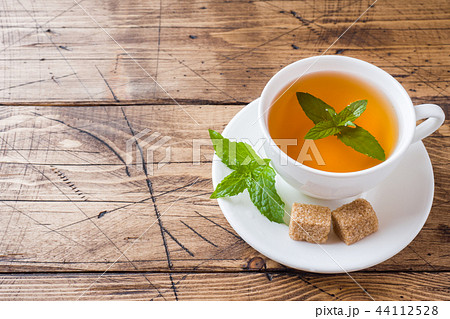 Cup of hot tea with mint and brown sugar Cup of hot tea with mint and brown sugar 44112528