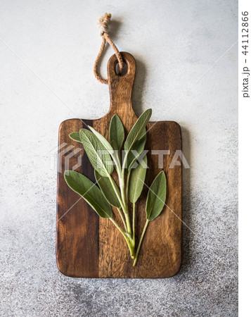 Short sprig of fresh sage on a wood board Short sprig of fresh sage on a wood board 44112866