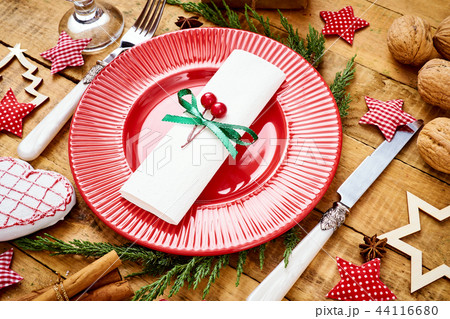 Christmas Eve background on an old wooden table with a red plate with a knife and fork 44116680