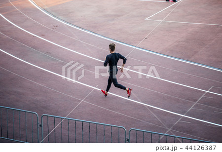 Top view Athlete running on running track. Runner sprinting on red running track in stadium 44126387