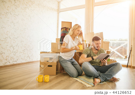 couple with book sitting on bed while moving into new home 44126652