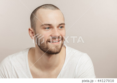 joyful young unshaven male looking aside 44127010