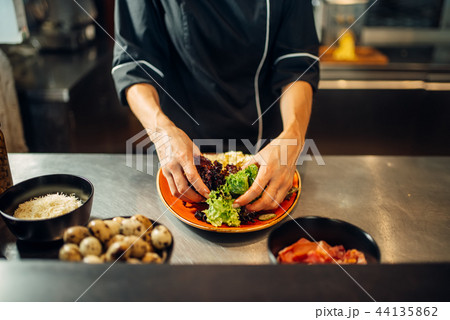 Female chef cooking meat salad on wooden table Female chef cooking meat salad on wooden table 44135862