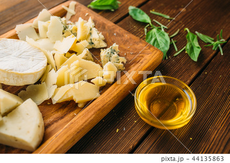 Cheese, oil and herb on wooden table closeup Cheese, oil and herb on wooden table closeup 44135863