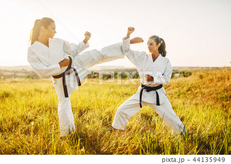 Two female karate with black belts fight in field 44135949