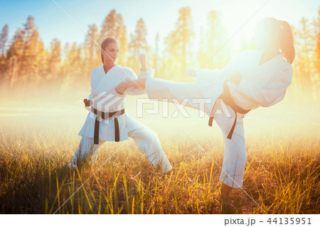 Two female karate in kimono fight in summer field 44135951