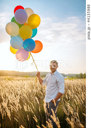 Man walks with bunch of balloons Man walks with bunch of balloons 44135986