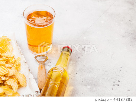 Glass and bottle of craft lager beer with crisps  44137885