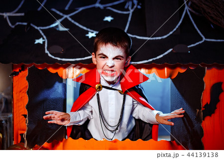 Portrait of a boy dressed in a costume of a vampire over grunge background. Portrait of a boy dressed in a costume of a vampire over grunge background. 44139138