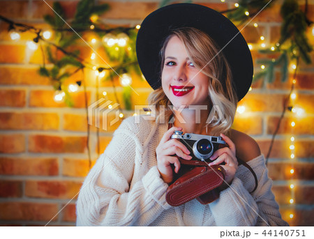 woman with vintage camera and Christmas lights woman with vintage camera and Christmas lights 44140751