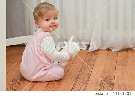 Little girl holding white toy in hands Little girl holding white toy in hands 44141509