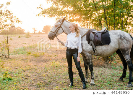 Young girl in uniform hugs her horse Young girl in uniform hugs her horse 44149950