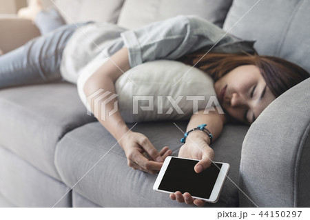 Young woman using smartphone at cozy home 44150297