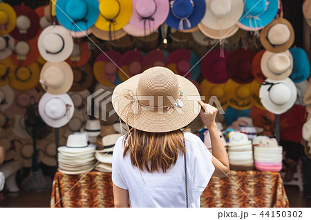 Young woman traveler looking for hat 44150302
