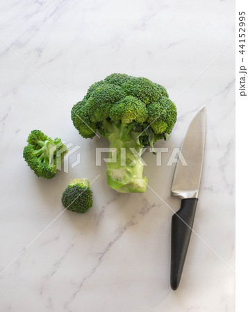 Green raw broccoli and knife Green raw broccoli and knife 44152995