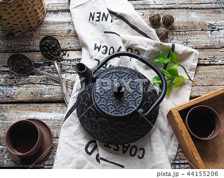 Black teapot, two bowls with green tea, mint  44155206