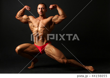 Young male bodybuilder standing knee bend, 44156055