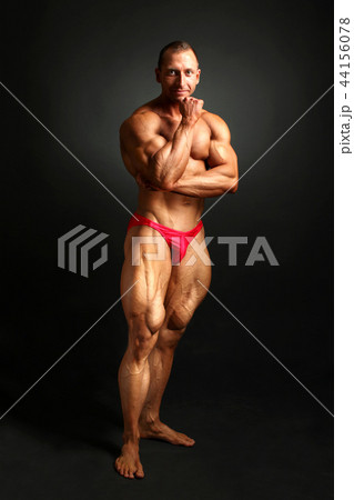 Male bodybuilder posing, hand under his chin 44156078