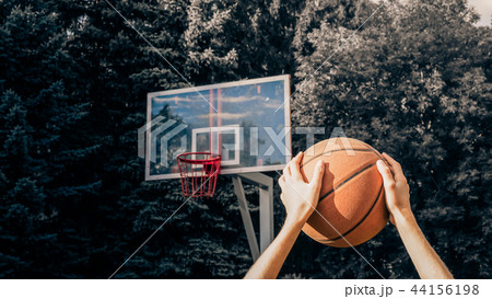 Man holding a basketball ball over his head 44156198