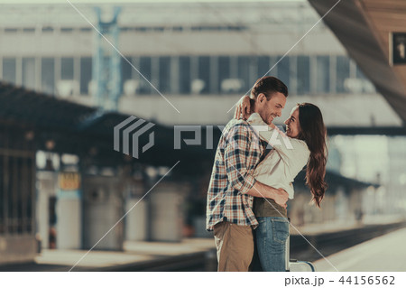 Positive man hugging cheerful female on platform 44156562