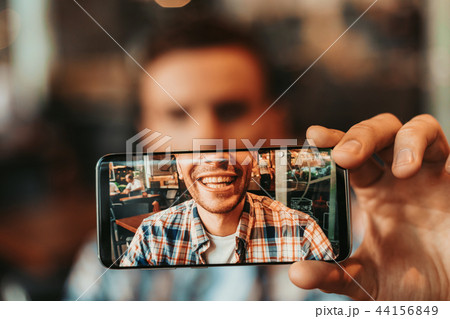 Optimistic man taking photo on the mobile Optimistic man taking photo on the mobile 44156849