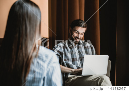 Jolly man is exploiting notebook while relaxing with woman Jolly man is exploiting notebook while relaxing with woman 44158267