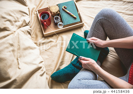 Female arms holding green copybook near salver 44158436