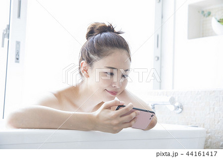 バスルームでスマホを見る女性 44161417