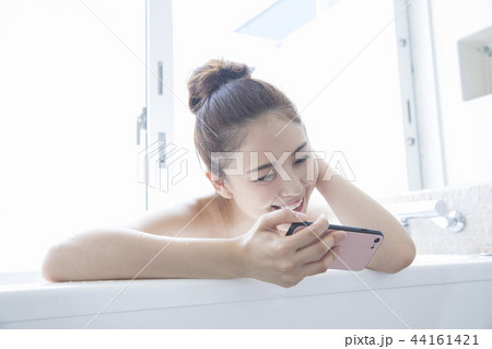 バスルームでスマホを見る女性 バスルームでスマホを見る女性 44161421