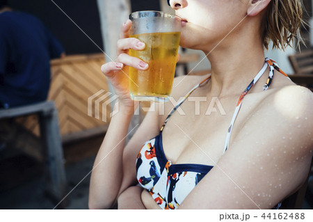 水着を着てビールを飲む女性の写真素材