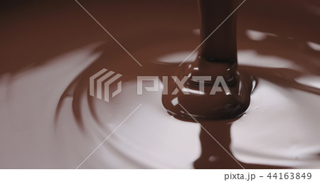 closeup pouring molten dark chocolate closeup pouring molten dark chocolate 44163849