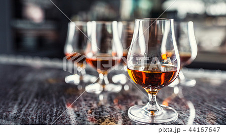 Cups with a cognac rum brandy or whiskey drink. 44167647