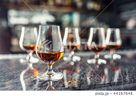 Cups with a cognac rum brandy or whiskey drink. 44167648