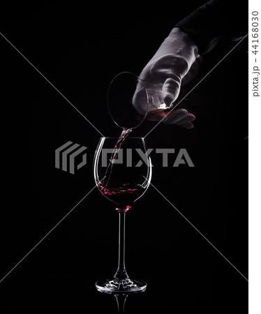 Hand pour red wine from decanter to glass 44168030
