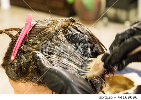 Hair dresser apply chemical color dye onto hair Hair dresser apply chemical color dye onto hair 44169096