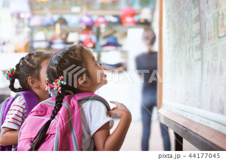 Two asian child girls with backpack looking at map Two asian child girls with backpack looking at map 44177045