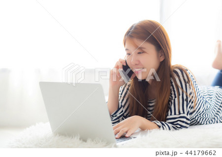 Beautiful woman lying on bed using laptop 44179662