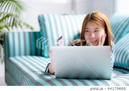 Beautiful asian woman lying users credit card Beautiful asian woman lying users credit card 44179666