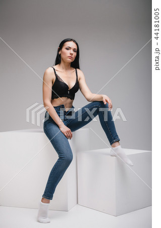 model sitting on cube in studio 44181005