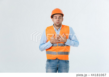 Young engineer opens his mouth shocked looking away, isolated on a white background. 44181067
