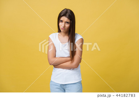 Indoor portrait of cute girl standing with crossed hands on belly, feeling awkward or suffering from 44182783