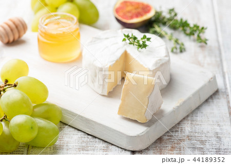 Cheese plate with brie, camembert, honey and fruits Cheese plate with brie, camembert, honey and fruits 44189352
