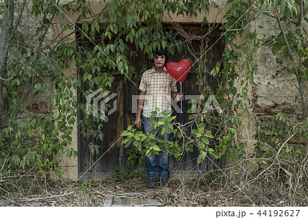 scary disfigured man with a balloon. 44192627