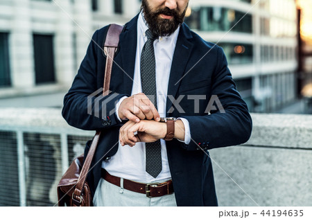 Unrecognizable businessman standing on the street in city, checking the time. 44194635