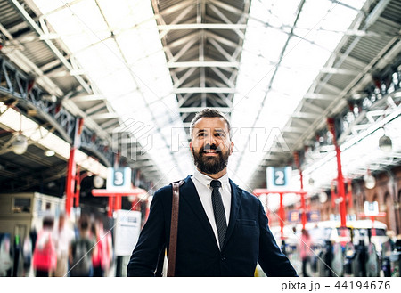 Businessman standing inside bus station in London. 44194676