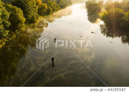 Aerial shot of a man fly fishing in a river during summer morning. 44195587