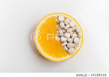 Tablets with vitamins in an orange slice. Tablets with vitamins in an orange slice. 44196418
